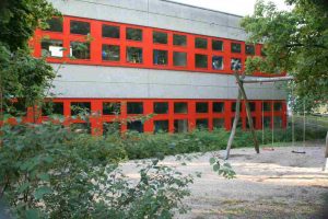 In 70er Jahren gebautes Schulhaus mit roten Fenstern