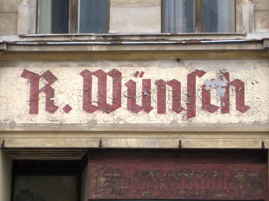 abgebröckelte Schrift auf Haussfassade; R. Wünsch
