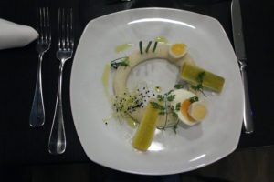 1. Gang: Lauch in Vinaigrette mit Ei im Ei auf Kartoffelcreme. Foto: Hensel
