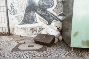 Ein Teddybär und ein alter Koffer in einer Straßenecke