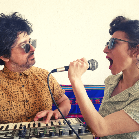 Zwei Musiker, links ein Mann mit Keyboard, rechts eine Frau die engagiert ins Mikrofon singt.