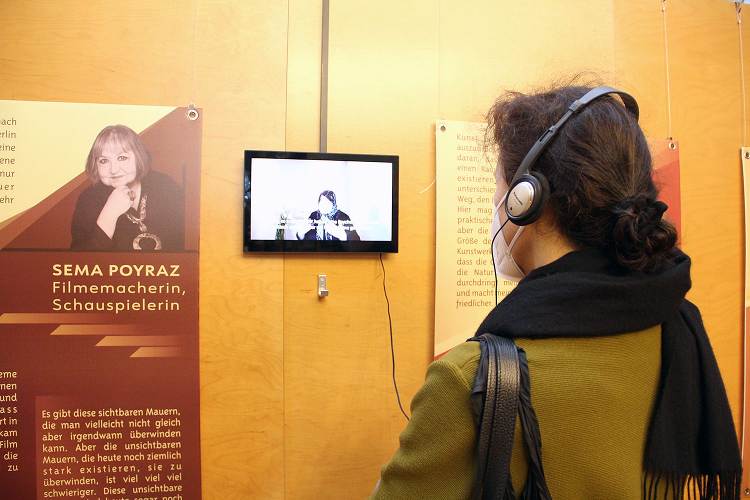 Eine Frau sieht sich eines der Videoporträts im Mitte Museum an