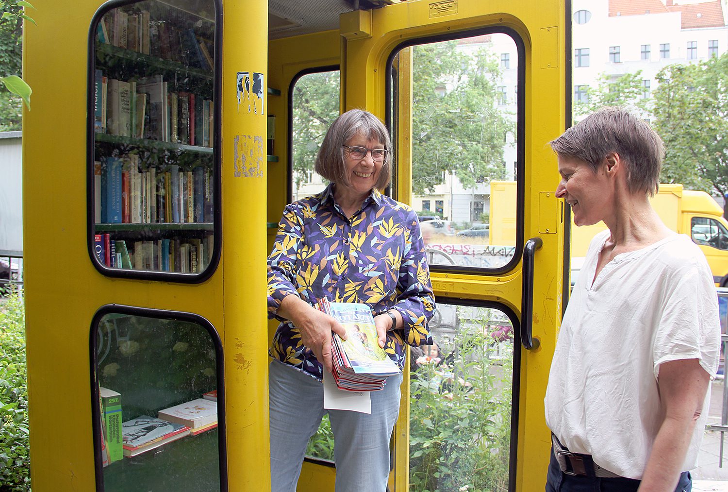 Cornelia zeigt Maike Janssen, was alles in der Bücherbox an der Fabrik Osloer Straße steht: Groschenromane. Foto: Hensel
