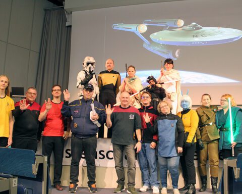 Dr. Hubert Zitt (Mitte) mit kostümierten Science Fiction-Fans bei der Star Trek-Vorlesung im November 2023. Foto: Hensel