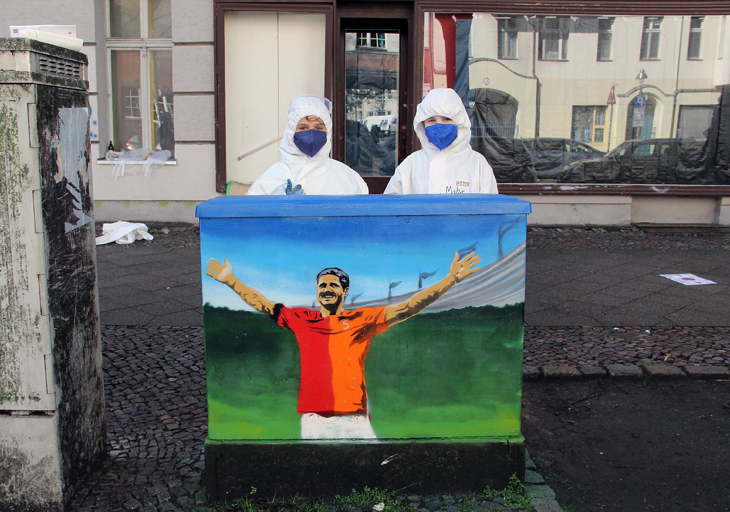 Mahir und Misem vor dem fertig gestalteten Stromkasten mit einem Motiv. Foto: Hensel