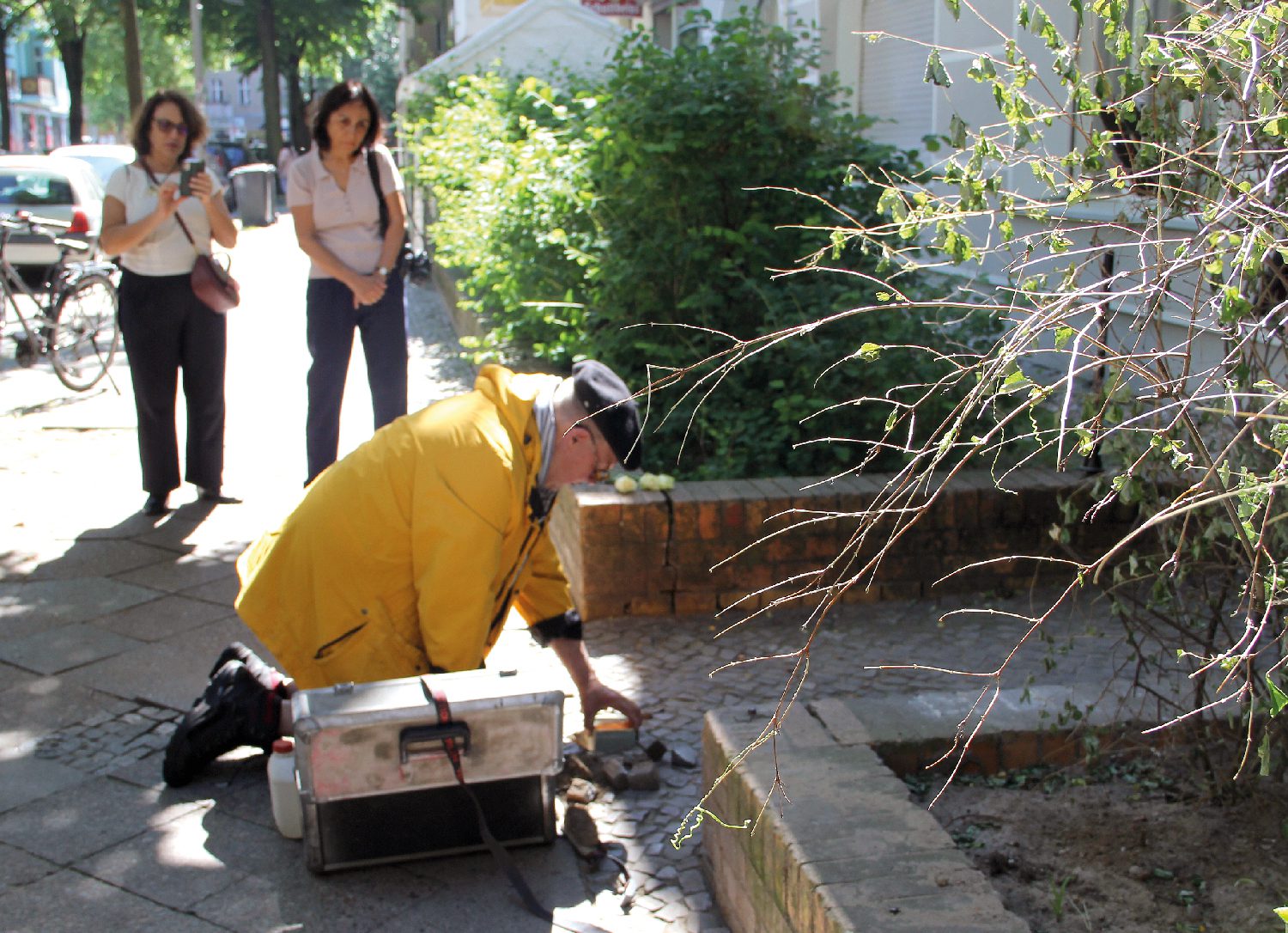 Der Stolperstein für Eva Langnas wird verlegt. Die Urenkelinnen Luzie (links) und Ruth Grünwald schauen zu. Foto: Hensel