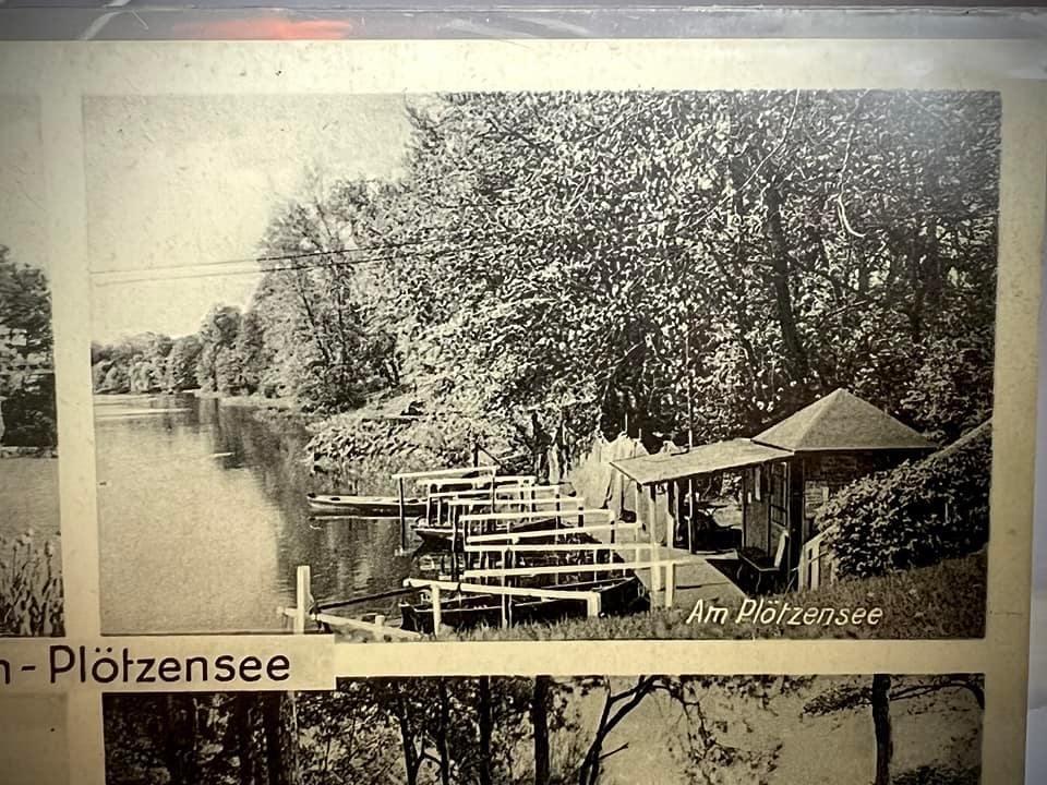 Alte Postkarte mit Grüßen vom Plötzensee. Zu sehen ein Hütte an der Stelle der Fischerpinte, dazu Bootsanleger und Tische hinter einem Sonnensegel